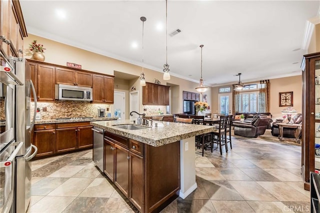 kitchen featuring tasteful backsplash, visible vents, a center island with sink, stainless steel appliances, and a sink