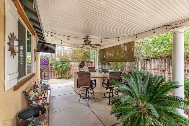 view of patio featuring outdoor dining area, ceiling fan, and fence