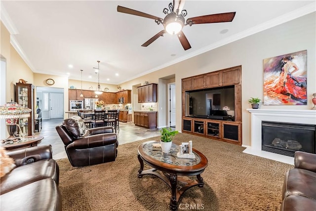 living room with a fireplace with flush hearth, a ceiling fan, and ornamental molding