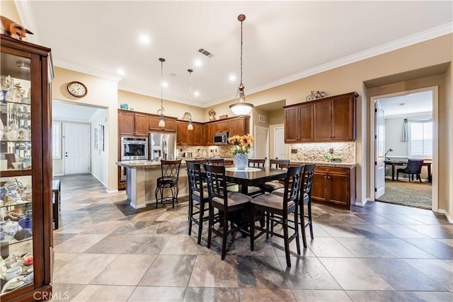 dining room with crown molding, baseboards, and visible vents