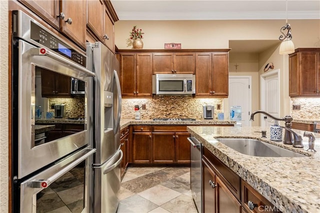 kitchen with tasteful backsplash, crown molding, light stone counters, stainless steel appliances, and a sink