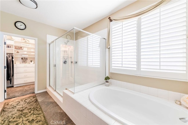 bathroom with a garden tub, a spacious closet, and a shower stall