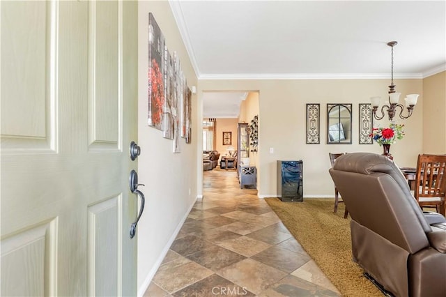 foyer featuring a notable chandelier, baseboards, and ornamental molding