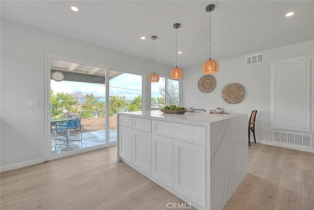 kitchen featuring light wood-type flooring, visible vents, white cabinetry, and light countertops