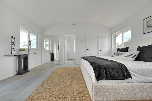 bedroom with lofted ceiling, multiple windows, and visible vents