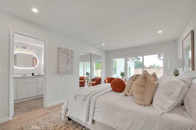 bedroom with recessed lighting, connected bathroom, a closet, light wood finished floors, and baseboards