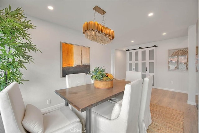 dining room featuring recessed lighting, baseboards, light wood-style floors, and a barn door