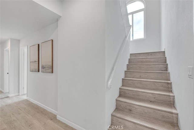 stairs with baseboards and wood finished floors