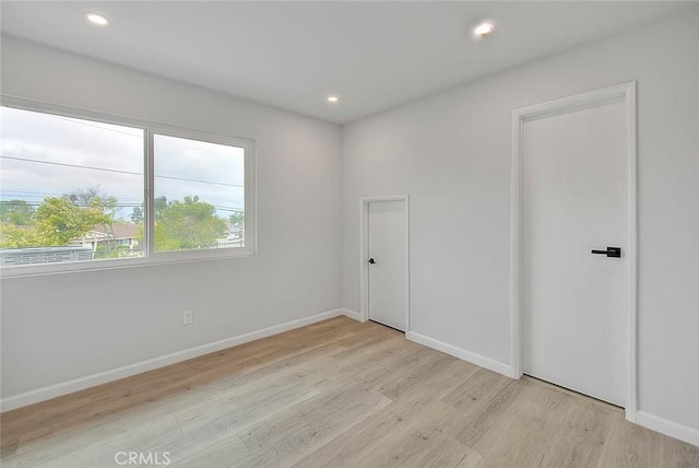 unfurnished bedroom featuring recessed lighting, light wood-style floors, and baseboards