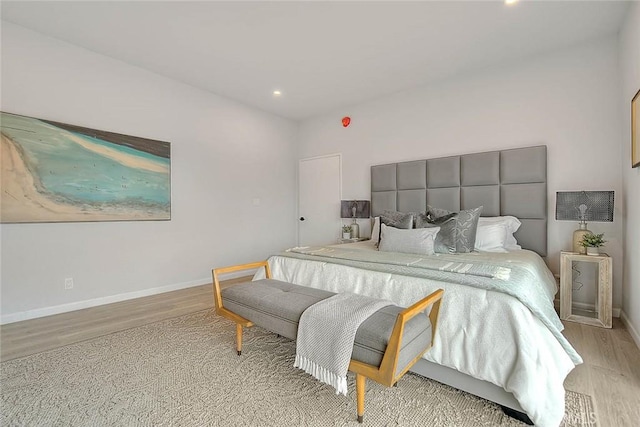 bedroom with light wood finished floors and baseboards