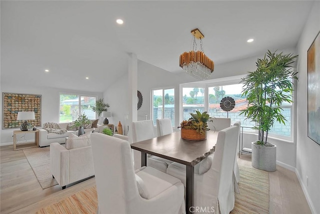 dining area with lofted ceiling, recessed lighting, baseboards, and a chandelier