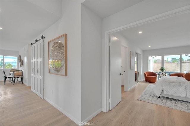 hallway featuring recessed lighting, baseboards, and light wood finished floors