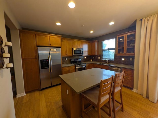 kitchen with tasteful backsplash, light wood-style flooring, stainless steel appliances, and glass insert cabinets