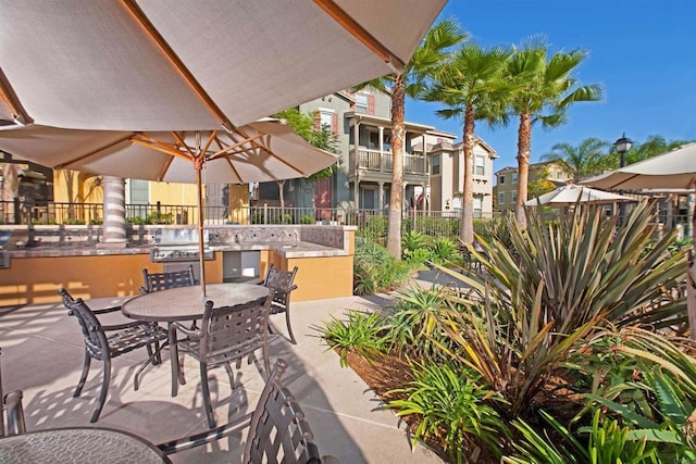 view of patio with outdoor dining area, an outdoor kitchen, and fence