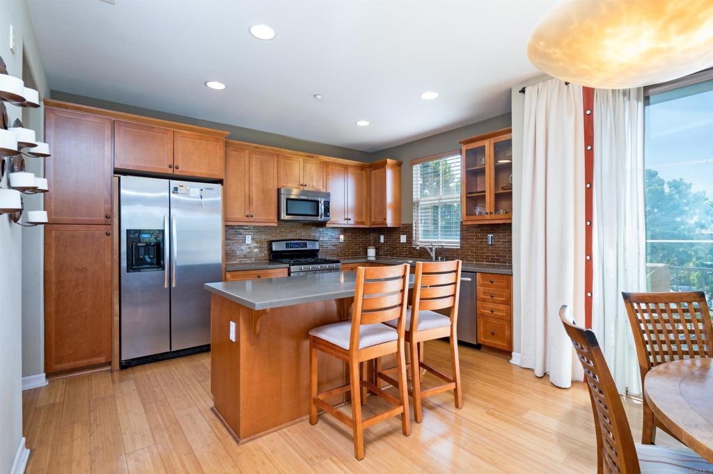 kitchen with light wood-style floors, tasteful backsplash, and stainless steel appliances