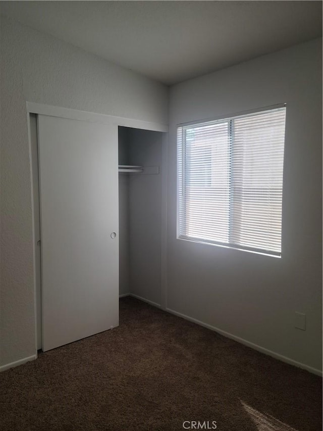 unfurnished bedroom featuring a closet and carpet flooring