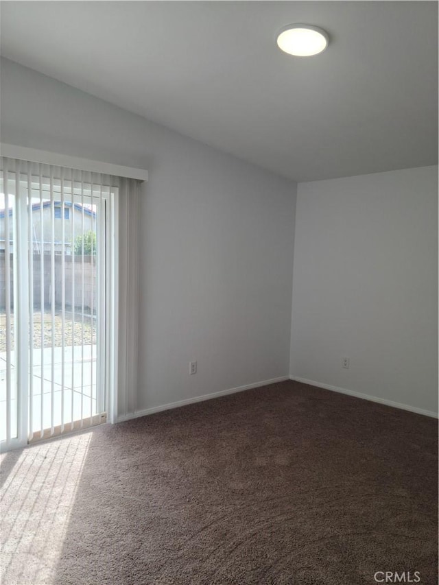 carpeted spare room featuring baseboards