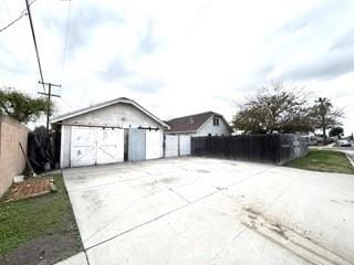 detached garage featuring fence