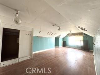 additional living space featuring visible vents, lofted ceiling, and wood finished floors