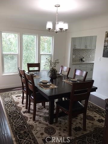 dining space with a wealth of natural light, an inviting chandelier, and baseboards