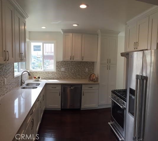 kitchen with white cabinetry, stainless steel range with gas stovetop, a sink, dishwasher, and refrigerator with ice dispenser