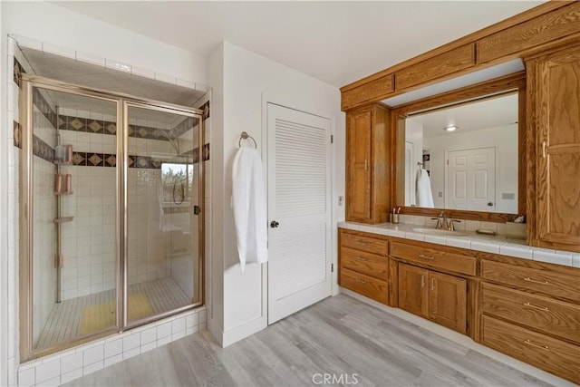 bathroom with vanity, a shower stall, and wood finished floors