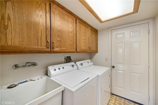 washroom featuring a sink, cabinet space, light floors, and separate washer and dryer