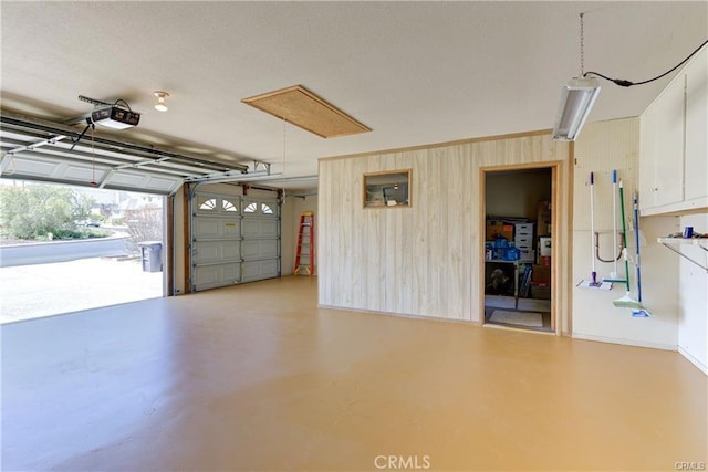 garage with wooden walls and a garage door opener