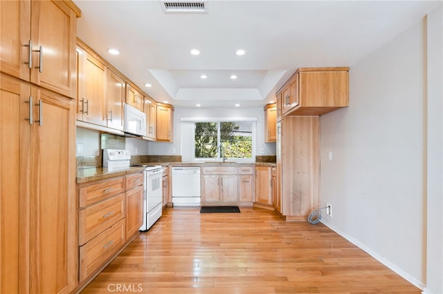 kitchen featuring white appliances, visible vents, light wood-style flooring, recessed lighting, and a raised ceiling