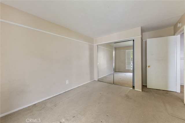 unfurnished bedroom with carpet flooring and a closet