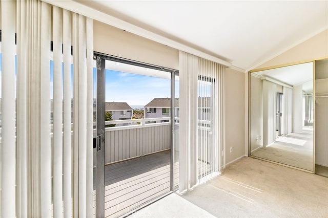 doorway to outside featuring carpet floors and vaulted ceiling