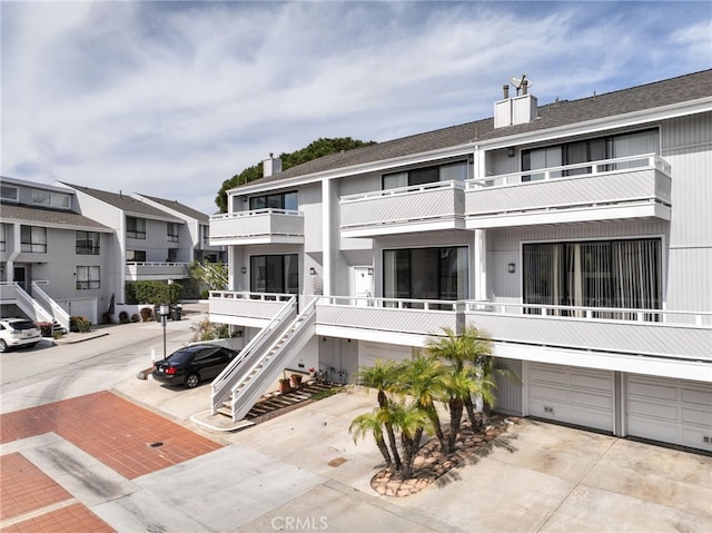 exterior space with a residential view, an attached garage, and driveway