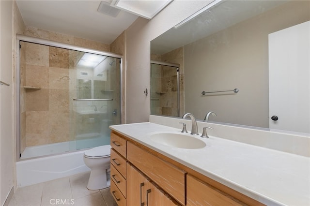 full bath with vanity, tile patterned floors, toilet, and bath / shower combo with glass door