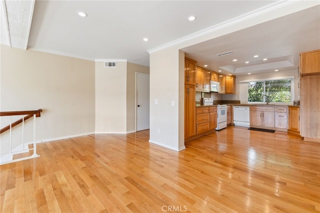 kitchen with visible vents, white appliances, baseboards, and light wood finished floors