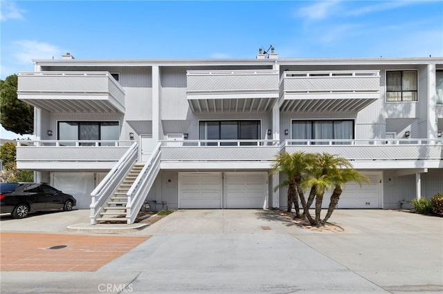 view of building exterior featuring driveway, stairs, and a garage