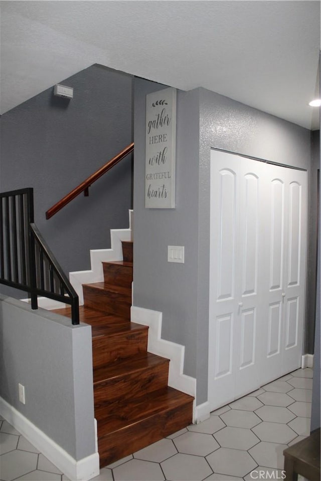 stairway with tile patterned flooring and baseboards