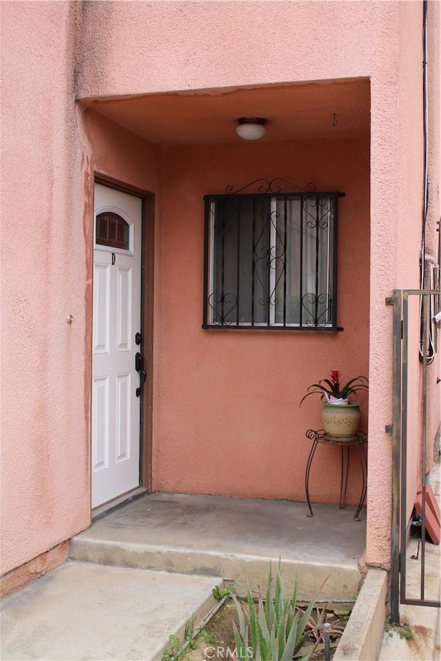 view of exterior entry featuring stucco siding