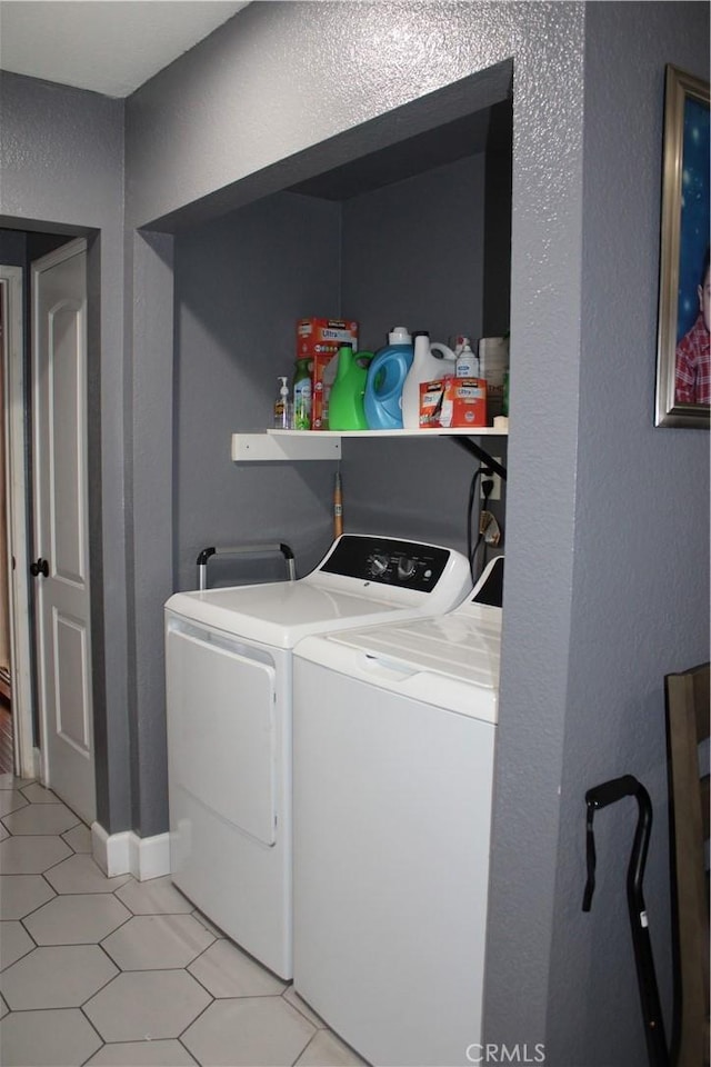 laundry room featuring light tile patterned floors, independent washer and dryer, laundry area, and a textured wall