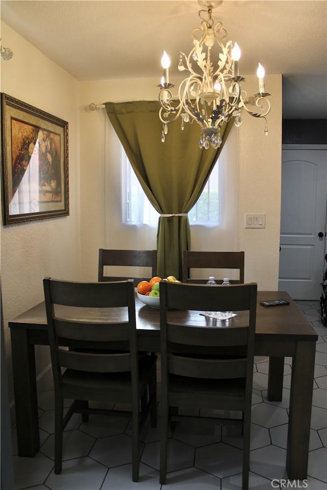 dining area with tile patterned floors and a chandelier