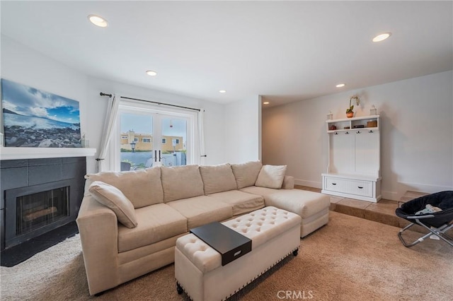 living area featuring a fireplace with flush hearth, recessed lighting, and baseboards