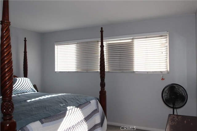 bedroom featuring baseboards and multiple windows