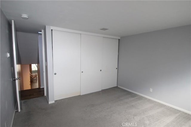 unfurnished bedroom with a closet, carpet, and visible vents