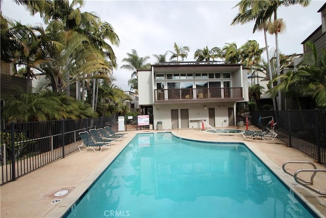 4545 Collwood Blvd Unit 19, San Diego, CA 92115 - back of house with a hot tub, a balcony, a patio, a community pool, and stucco siding