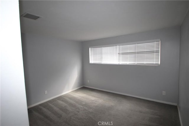 carpeted spare room featuring visible vents and baseboards