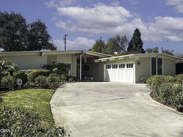 mid-century inspired home featuring driveway and an attached garage