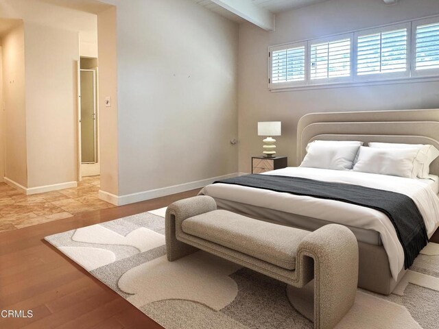 bedroom with beam ceiling, light wood-style flooring, and baseboards