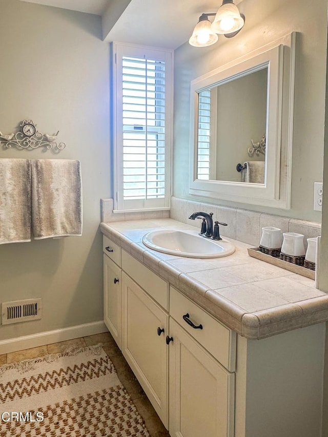 bathroom featuring tile patterned floors, visible vents, vanity, and baseboards