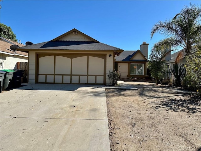 ranch-style house with an attached garage, concrete driveway, and fence