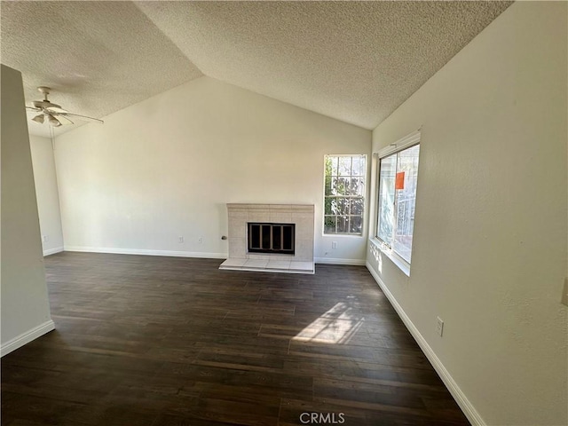 unfurnished living room featuring wood finished floors, a fireplace, baseboards, and lofted ceiling