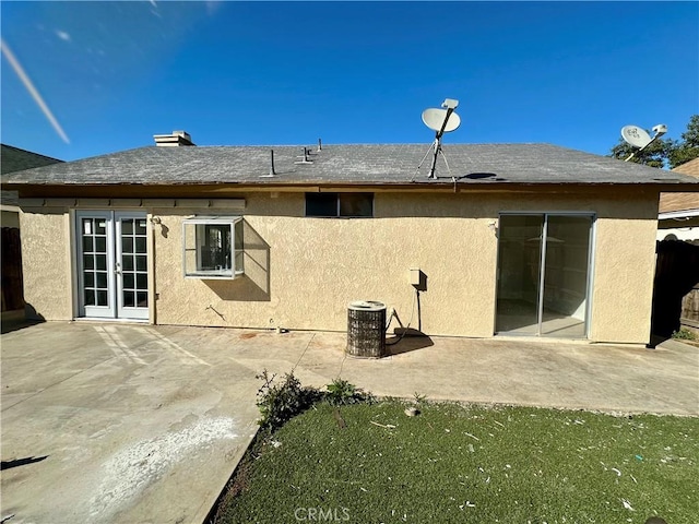 rear view of house featuring stucco siding, a patio, central AC unit, and french doors